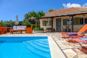 a villa with a swimming pool in front of a house at Melodia in Fternón +4 photos