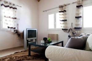 a living room with a couch and a table and a tv at Melodia in Fternón