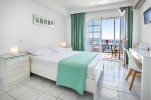 a bedroom with a bed and a desk and a balcony at D&D Holiday Studios in Potos