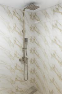 a shower in a bathroom with white marble walls at HOTEL RANCHO UPLISTSIKHE სასტუმრო რანჩო უიფლისციხე in Uplistsikhe +20 photos
