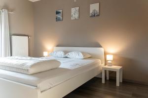 a bedroom with a white bed with two pillows at l'hôt'antique in Vielsalm