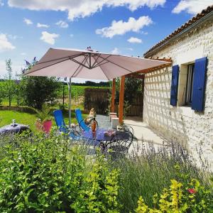 Sainte-GemmeにあるGite de la Barrièreのパティオ(テーブル、傘付)