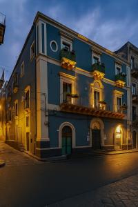 a blue building with two balconies on a street at Dimore Sangiuliano in Catania