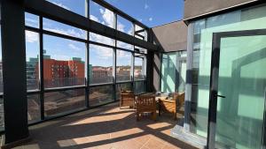 a balcony with a table and chairs in a building with windows at B&B HOTEL Burgos in Burgos