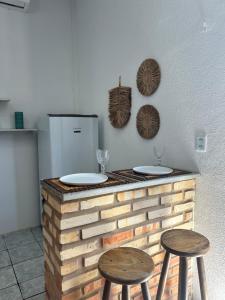 a counter with two stools and a refrigerator at Suite Canoa azul 1 in Aracati
