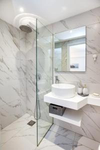 a white bathroom with a sink and a mirror at D&D Holiday Studios in Potos