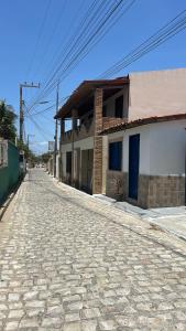 an empty cobblestone street next to a building at Suite Canoa azul 1 in Aracati