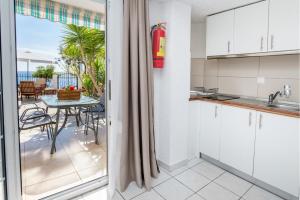 a kitchen with a view of a patio with a table at D&D Holiday Studios in Potos