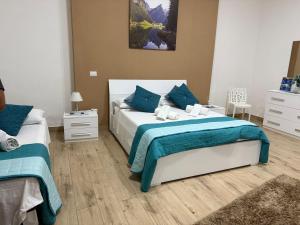 una camera da letto con due letti con cuscini blu di Roan home Pompei a Pompei