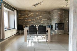 a dining room with a table and black chairs at l'hôt'antique in Vielsalm