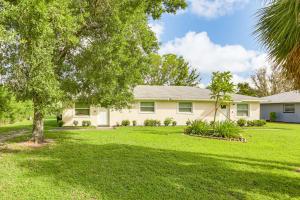 a house with a green yard with a tree at Pet-Friendly Duplex with Large Yard in Fort Myers! in Fort Myers