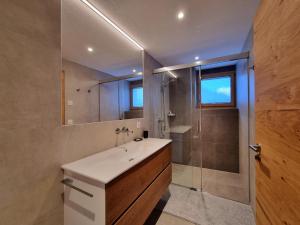un baño con lavabo y ducha en Berghof 2nd Floor, en Saas-Fee 50 fotos más