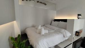 een witte slaapkamer met een bed met witte kussens bij Aristotelous Luxury Stay in Thessaloniki