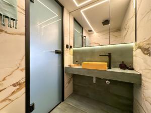 een badkamer met een wastafel en een spiegel bij Aristotelous Luxury Stay in Thessaloniki