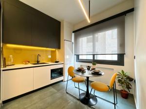 een keuken met een tafel, stoelen en een spoelbak bij Aristotelous Luxury Stay in Thessaloniki