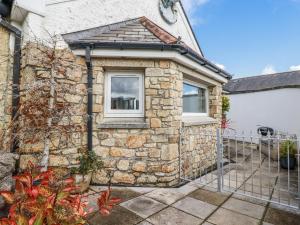 a stone house with a gate and a garage at Chapel Green Studio 2 in St Austell