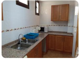 a kitchen with a sink and a microwave at Casa Rural Trinquete in Montán