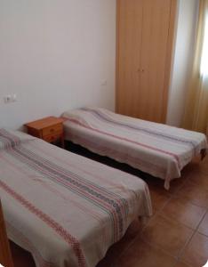 two beds sitting in a room with at Casa Rural Trinquete in Montán