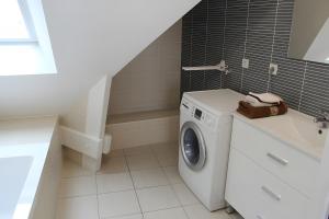 eine weiße Waschmaschine im Bad mit Waschbecken in der Unterkunft Résidence Brise de Mer - 3 in Port Nayalo + 6 Fotos