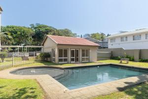 マーゲートにあるLuxurious Lagoon Retreatの庭にスイミングプールがある家