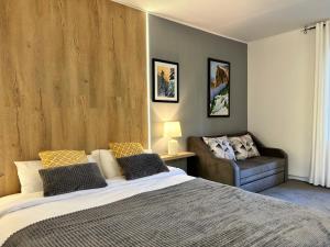 a bedroom with a large bed and a couch at Devonshire Lodge Chalet in Bansko