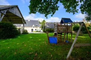 un parque infantil en un patio con una casa en Villa Kerdrean, en Cléguérec