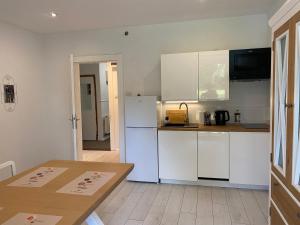a kitchen with a white refrigerator and a table at Kino na łące apartament z jacuzzi i prywatną salą kinową in Wojcieszyce