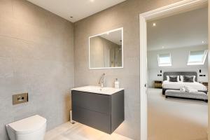 a bathroom with a sink and a toilet and a bed at The Royal Paddock in Ascot +35 photos