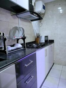 a kitchen with a stove and a counter top at UG shortlet apartment in Isagatedo +19 photos