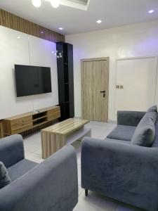 a living room with two couches and a flat screen tv at UG shortlet apartment in Isagatedo
