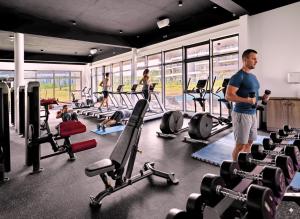 a man standing in a gym with people exercising at Sky View Penthouse in Moka