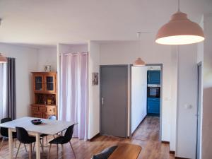 Orgnac-lʼAvenにあるGites de l'avenのテーブルと椅子のあるキッチンとダイニングルーム