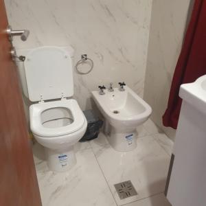 a white bathroom with a toilet and a sink at Monoambiuente equipado para 2 personas en San Miguel de Tucumán in San Miguel de Tucumán
