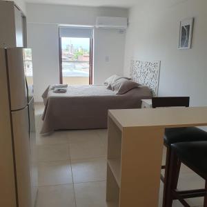 a bedroom with a bed and a table and a window at Monoambiuente equipado para 2 personas en San Miguel de Tucumán in San Miguel de Tucumán