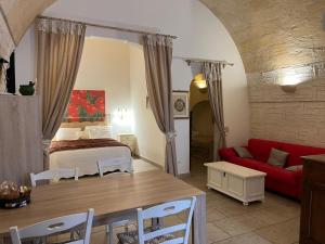 a living room with a bed and a red couch at Suite San Francesco in Grottaglie