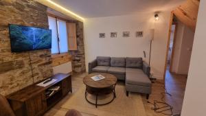 una sala de estar con un sofá y una mesa en Llivia 1876, en Llivia