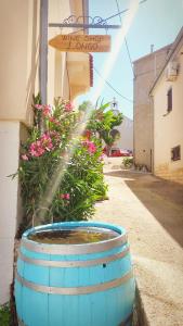 a water fountain in a barrel on the side of a building at Gospoja Park & Beach Apartment Vrbnik in Vrbnik
