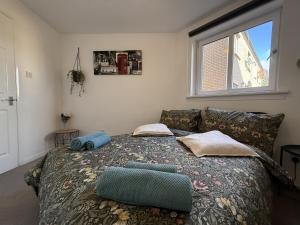 une chambre avec un lit avec des oreillers et une fenêtre dans l'établissement Newly furnished comfortable property!, à Dalmuir