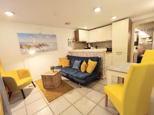 a living room with a blue couch and yellow chairs at AS Lucana Apartment - Ground floor in Vis