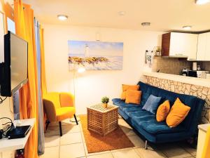 a living room with a blue couch and a yellow chair at AS Lucana Apartment - Ground floor in Vis