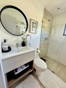 a bathroom with a sink and a toilet and a mirror at Apartment Luxury ONA Residence, Punta Cana in Punta Cana