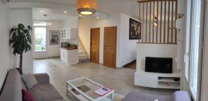 ein Wohnzimmer mit Sofa und Fernseher in der Unterkunft Maison moderne au calme,coeur de ville-3 chambres 2 sdb in Sens