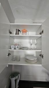 eine Küche mit weißen Regalen mit Tellern und Gläsern in der Unterkunft Casa Turmalina in Corralejo