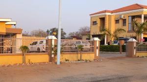 a yellow fence in front of a house at Top Stay Inn in Kasane