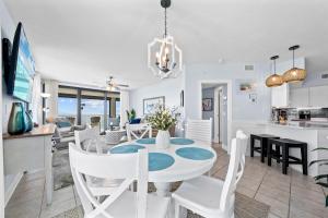 een eetkamer en een keuken met een witte tafel en stoelen bij Sunrise Serinity Summer House 1101A in Orange Beach +34 foto's