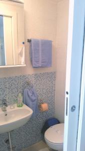 a bathroom with a sink and a toilet and a mirror at Gospoja Park & Beach Apartment Vrbnik in Vrbnik