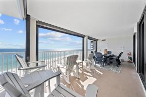 een balkon met stoelen en een tafel en uitzicht op de oceaan bij Sunrise Serinity Summer House 1101A in Orange Beach