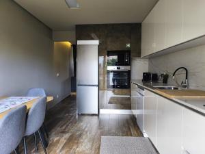 a kitchen with white cabinets and a counter top at Refúgio da Nau in Vila do Conde