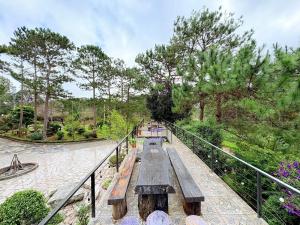 a wooden bench sitting on a bridge in a park at HeniSi Homestay Măng Đen Villa in Kon Von Kla +23 photos