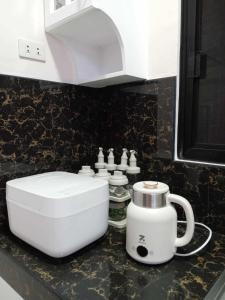 a kitchen counter with a toilet and a coffee pot at Cozy Home in Dipolog by Aveinz in Dipolog +27 photos